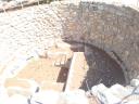 043. Well near entrance οf Knossos palace - One of three stone-lined pits about 5-6 meters in diameter and 3 meters deep. Evans assumed that they were built to quickly drain away surface water. Probably, the wells were used as storages for something or for sacrifice during religious ceremonies.