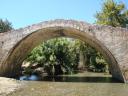 052. Venetian bridge - Bridge over the Megalos Potamos river (Ο Μεγάλος Ποταμός) upstream. There is snack-tavern nearby by the bridge ‘Η Γέφυρα.’ Geese, blue dragonflies and pink flowers are found at the river. You can wander for some time along the river and even dip into the cold water like locals.